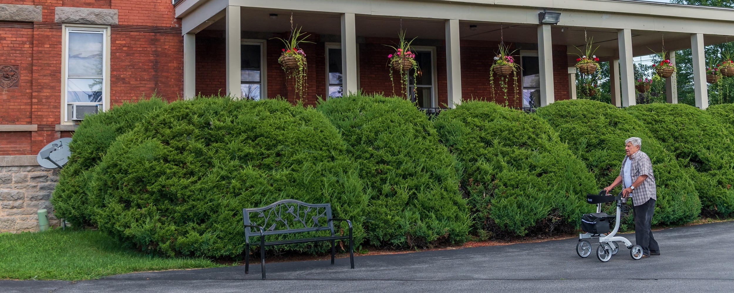 senior walking with a walker in front of the Samuel F Vilas Home